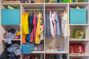 Open wardrobe with things and toys in the children's room